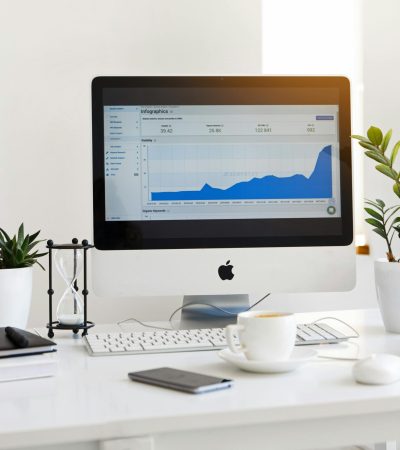 pexels-photo-572056-572056 A clean, contemporary workspace featuring a desktop with analytics on the screen and plants for a fresh look.